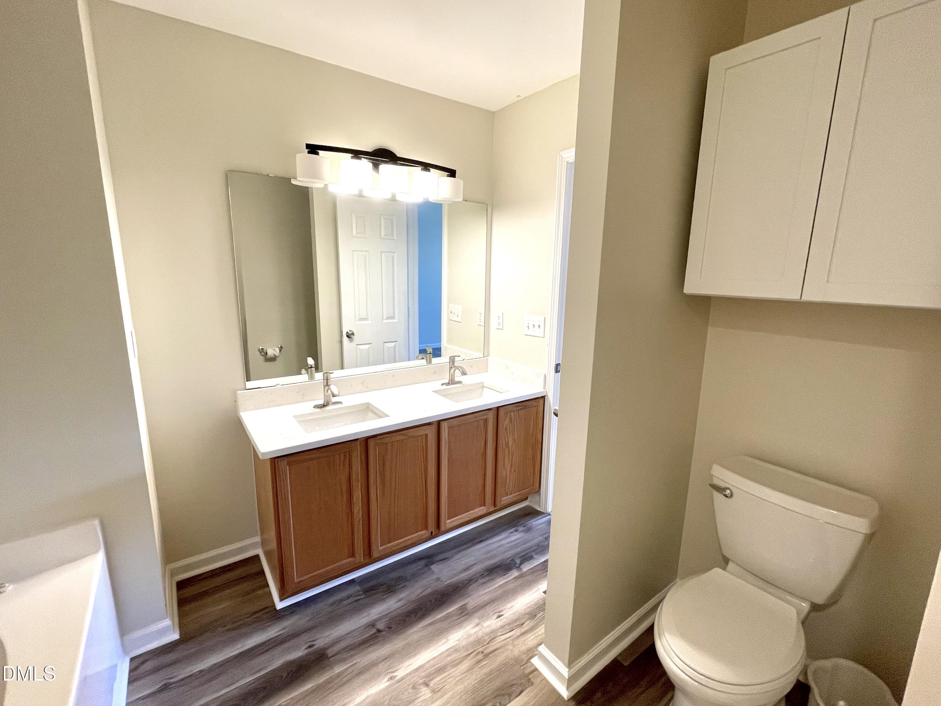 5506 Grand Mesa Drive Durham, NC 27713 - Photo 24 of 28 a bathroom with a sink mirror vanity and toilet
