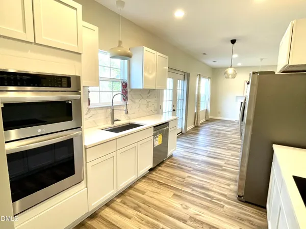 a kitchen with stainless steel appliances a stove a sink and a refrigerator