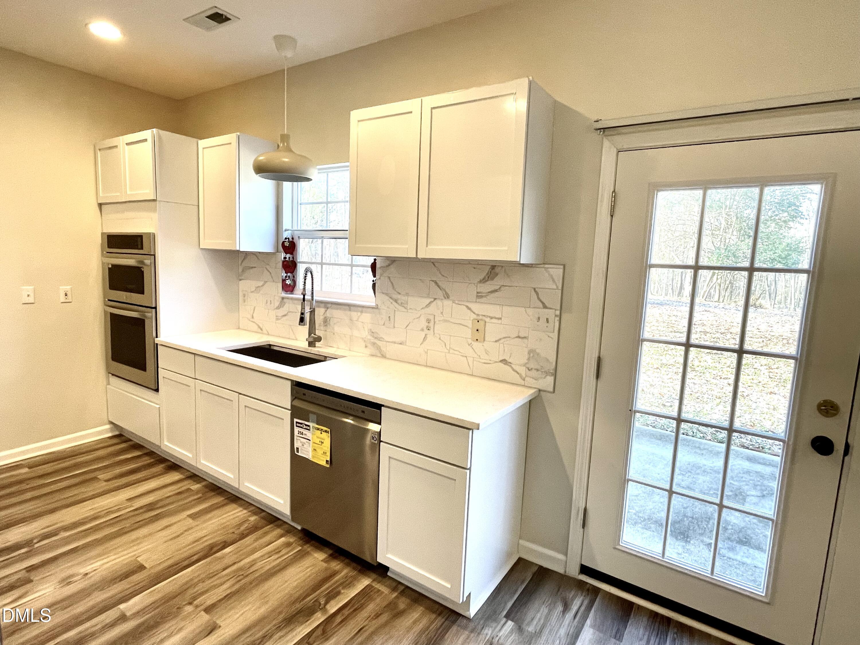 5506 Grand Mesa Drive Durham, NC 27713 - Photo 8 of 28 a kitchen with stainless steel appliances granite countertop a stove a sink and a refrigerator