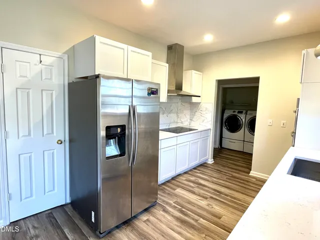 a kitchen with stainless steel appliances a refrigerator and wooden floor