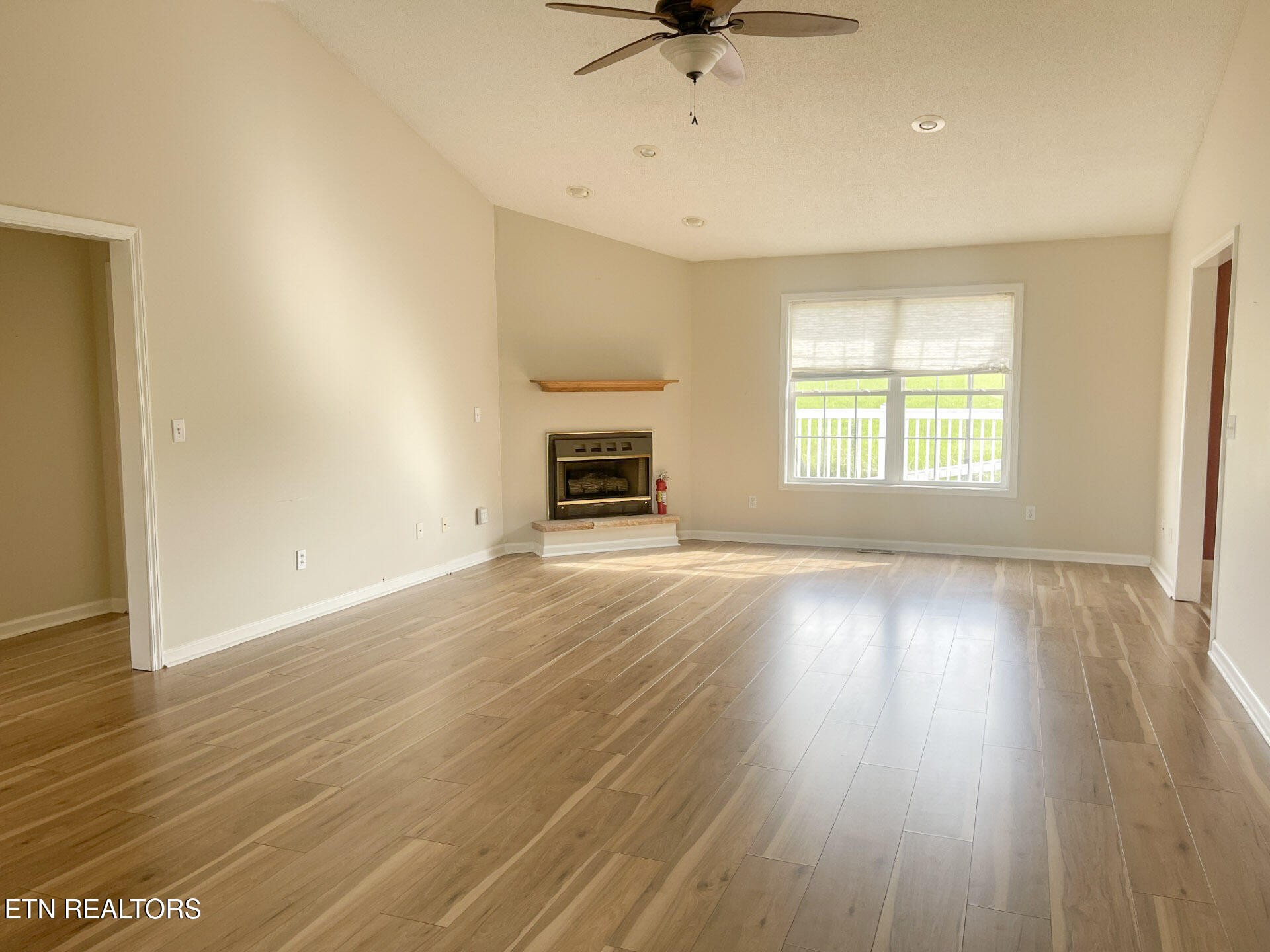 299 Jesse Loop Crossville, TN 38555 - Photo 6 of 32 an empty room with wooden floor fireplace and windows