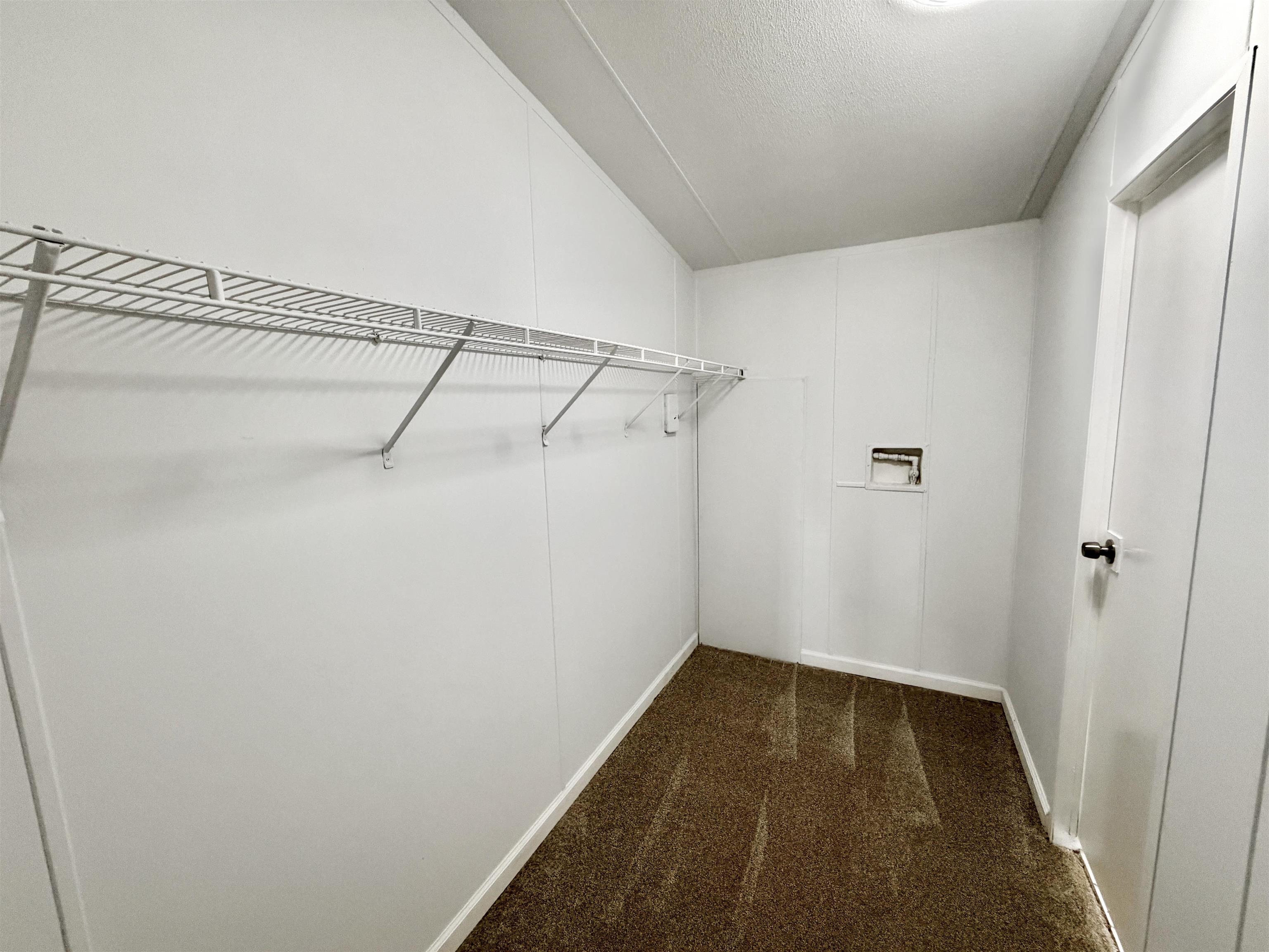 1655 Fayne Road Brighton, TN 38011 - Photo 22 of 28 Utility room featuring wire shelving, wall paneling, and a door with a black knob