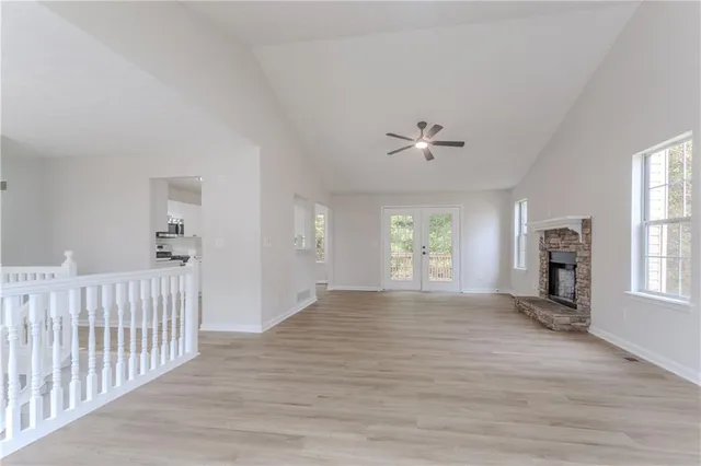 a view of an empty room with a window and wooden floor