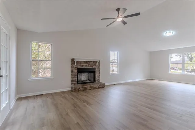 wooden floor fireplace and windows in an empty room
