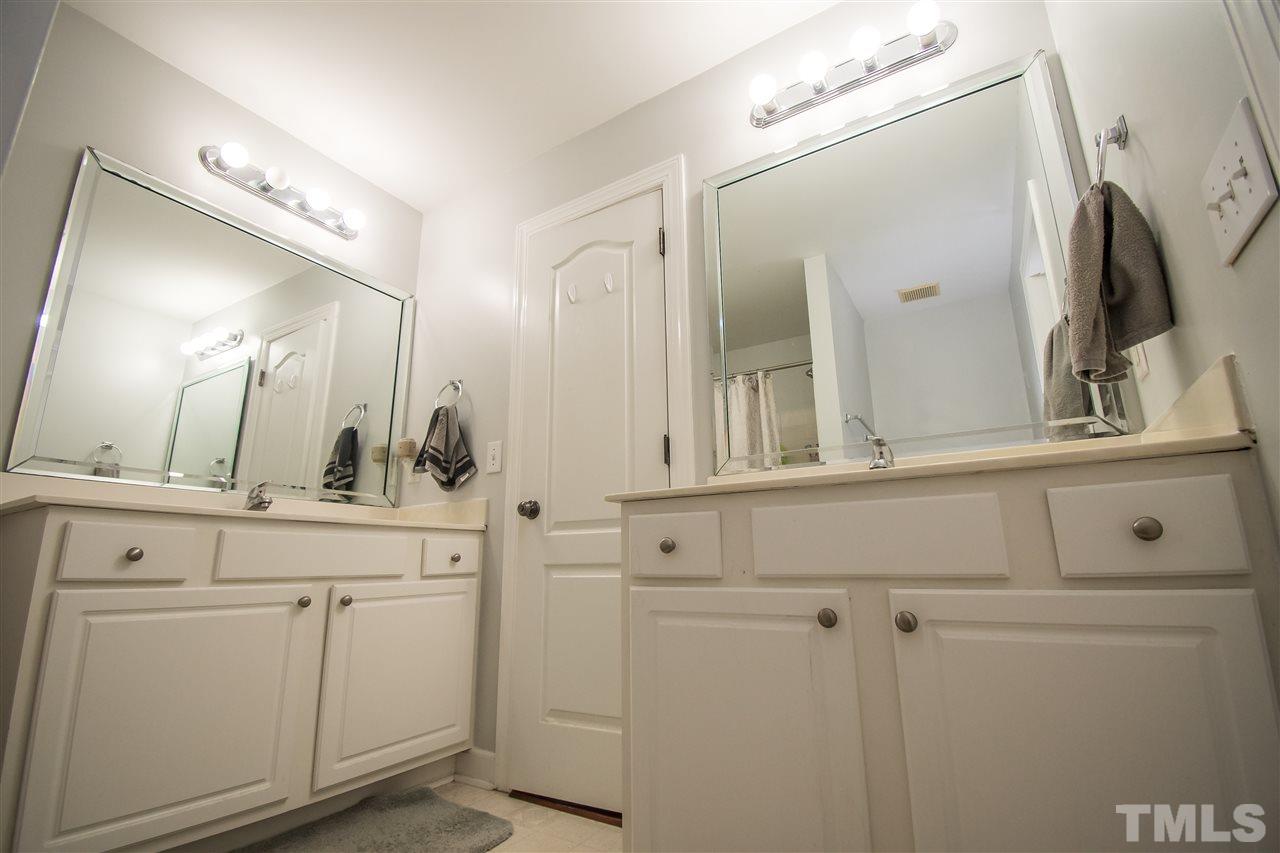 4813 Kure Road Raleigh, NC 27603 - Photo 14 of 25 a bathroom with cabinets a sink and a mirror