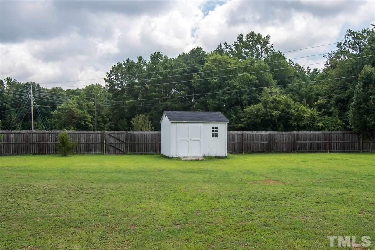 4813 Kure Road Raleigh, NC 27603 - Photo 22 of 25 a house with a field and wooden fence