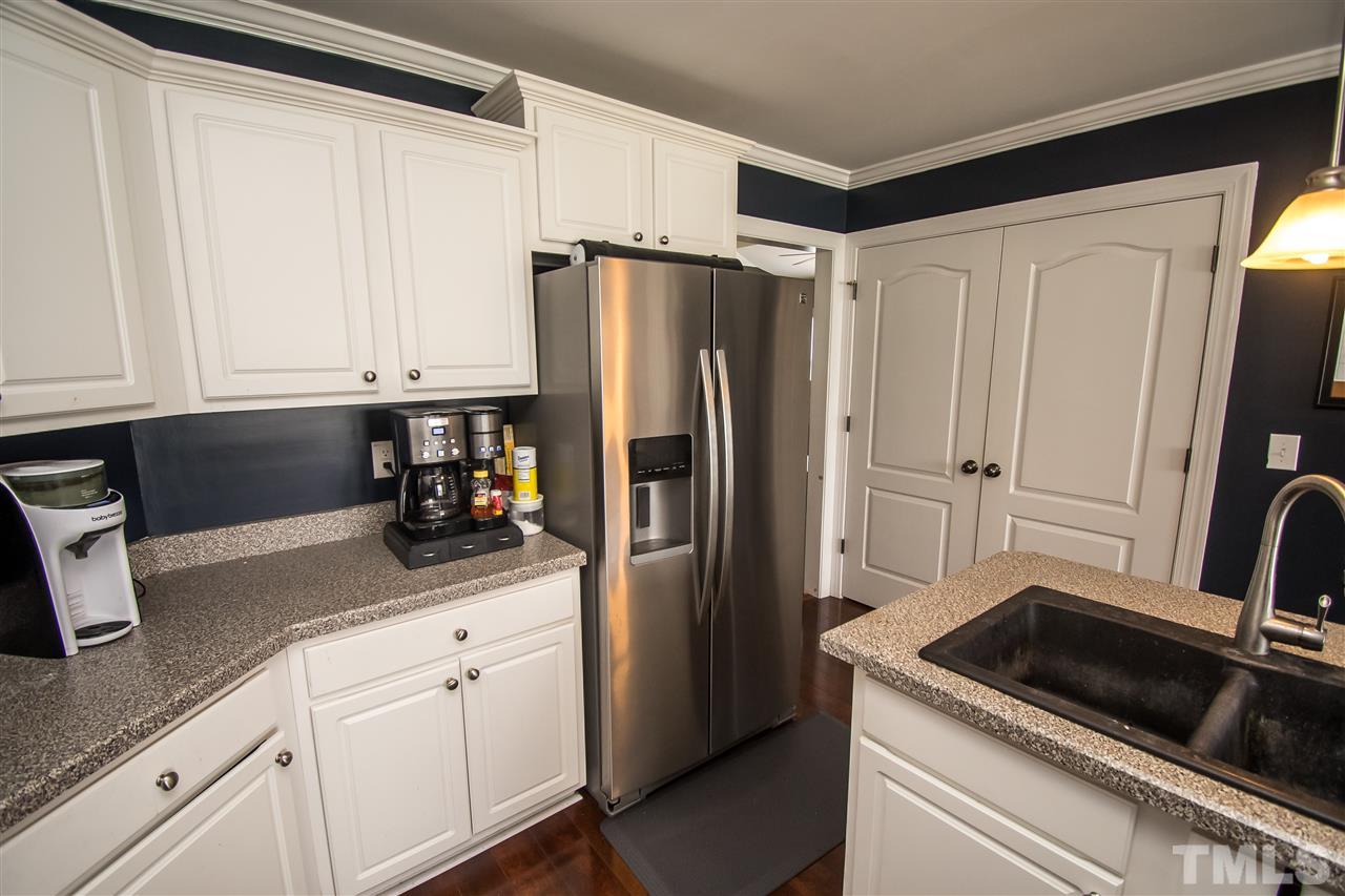 4813 Kure Road Raleigh, NC 27603 - Photo 8 of 25 a kitchen with white cabinets and stainless steel appliances