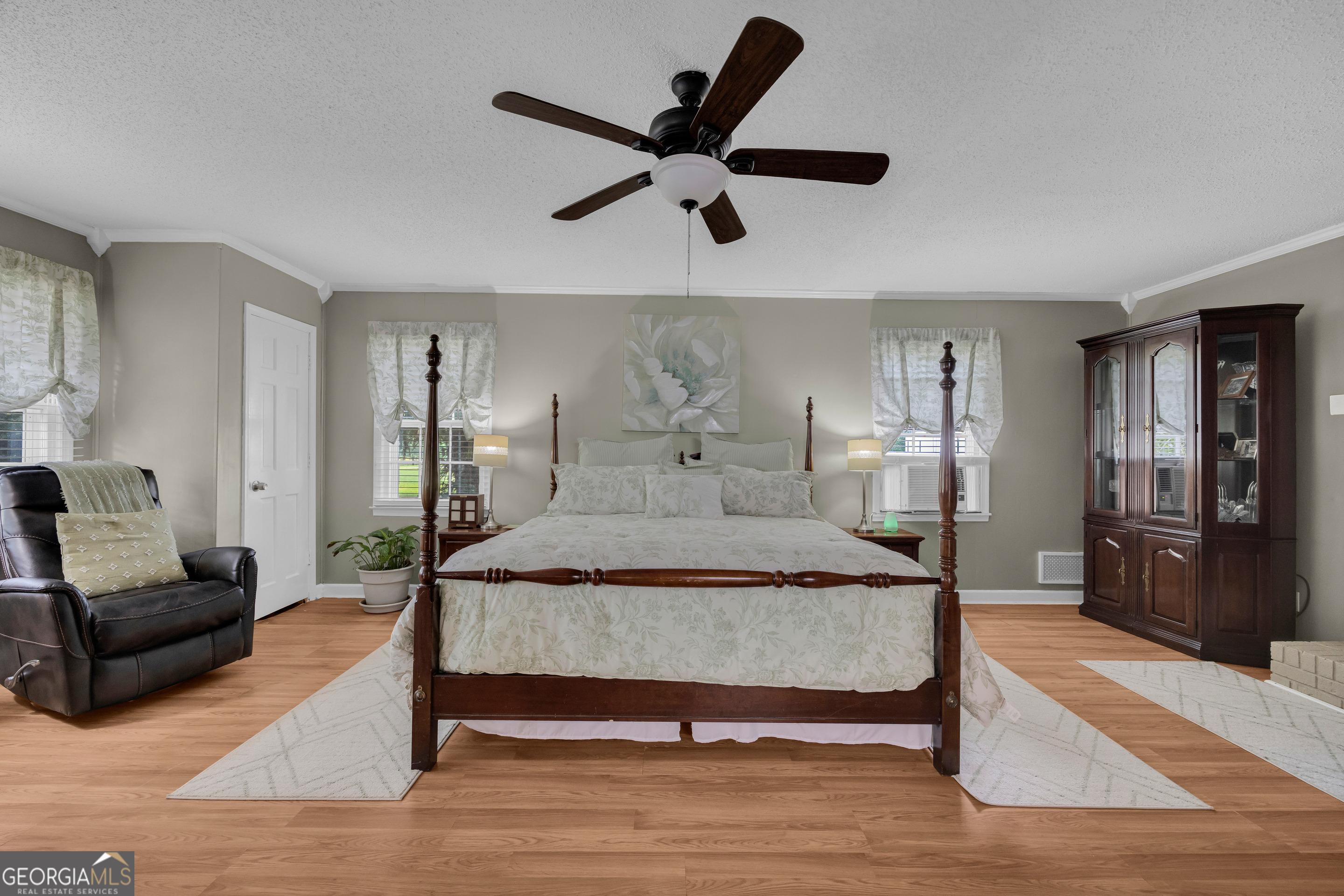 1270 Airline-Goldmine Road Canon, GA 30520 - Photo 13 of 107 a spacious bedroom with a bed a couch and a ceiling fan