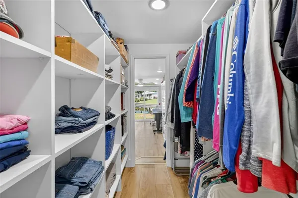a view of walk in closet with clothes and shoes