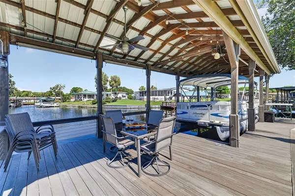 a patio with wooden floor a barbeque grill with dining table and chairs