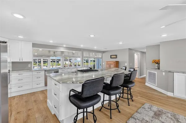 a kitchen with stainless steel appliances kitchen island granite countertop a table and chairs in it