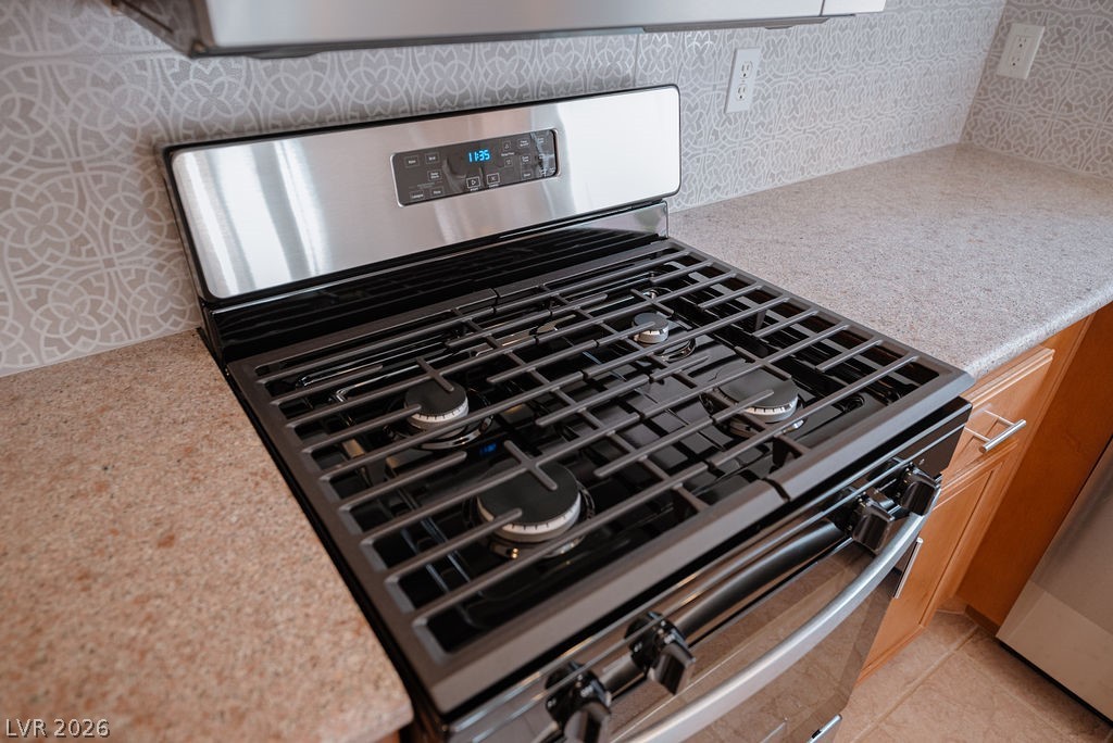 3591 Driving Range Street Las Vegas, NV 89122 - Photo 38 of 79 This modern kitchen features a sleek gas range, perfect for culinary adventures.