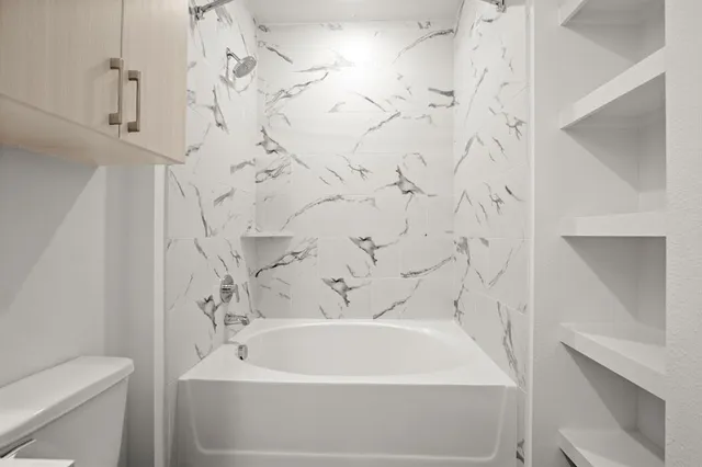 a white bath tub sitting next to a white toilet