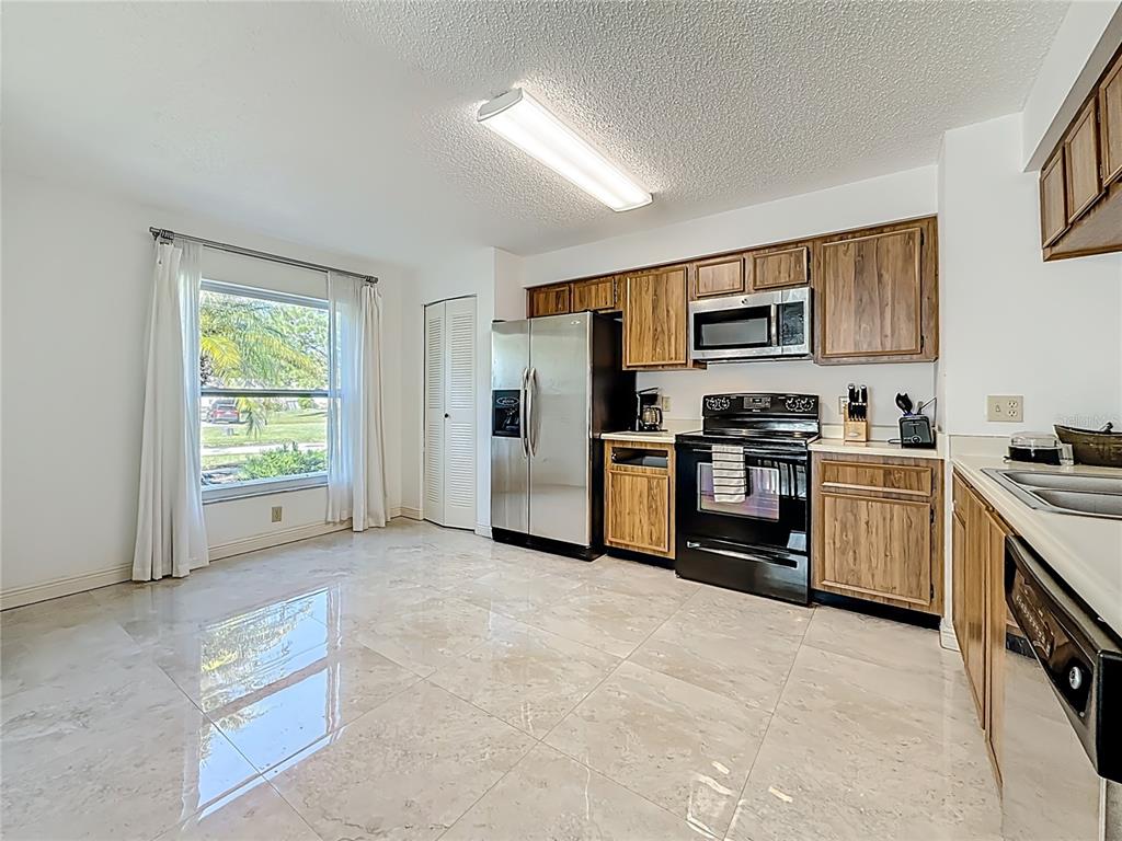 1909 Castle Bay Court Oldsmar, FL 34677 - Photo 19 of 48 a kitchen with stainless steel appliances a stove a refrigerator a sink a counter top space and cabinets