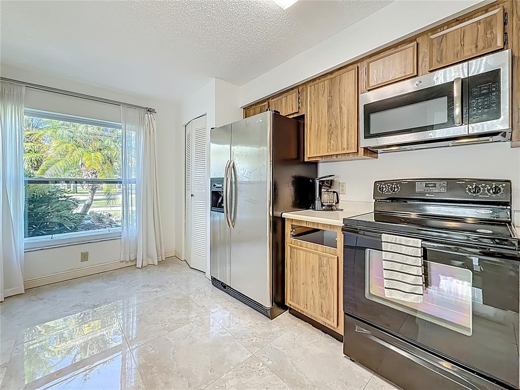 1909 Castle Bay Court Oldsmar, FL 34677 - Photo 21 of 48 a kitchen with stainless steel appliances granite countertop a refrigerator a stove a sink and a microwave