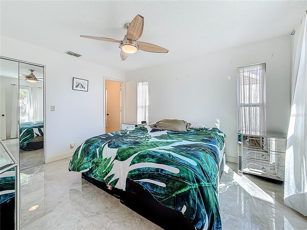1909 Castle Bay Court Oldsmar, FL 34677 - Photo 25 of 48 a bedroom with a bed and a chandelier
