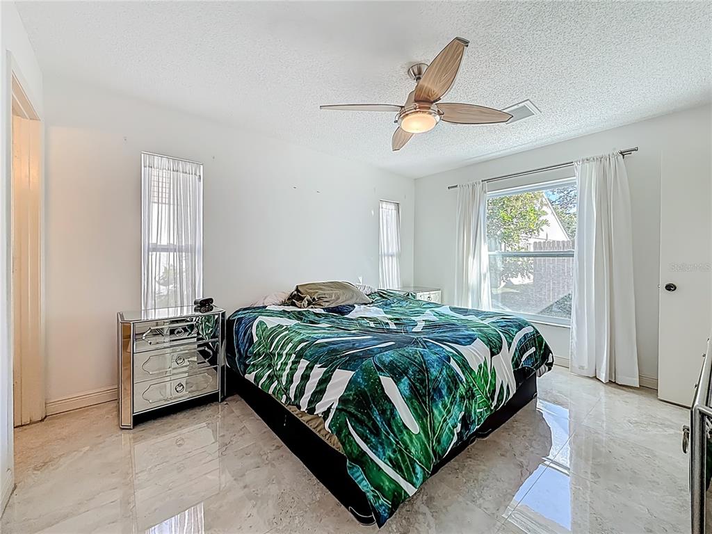 1909 Castle Bay Court Oldsmar, FL 34677 - Photo 26 of 48 a bedroom with a bed next to a window and a chandelier