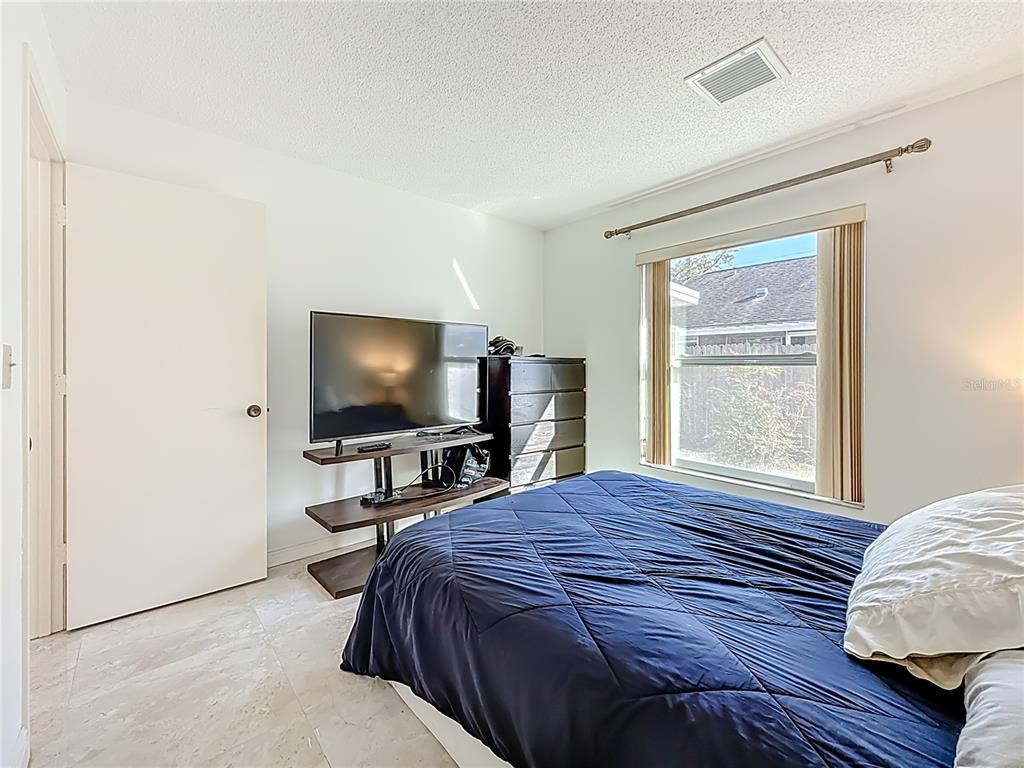 1909 Castle Bay Court Oldsmar, FL 34677 - Photo 28 of 48 a bedroom with a bed and a flat screen tv