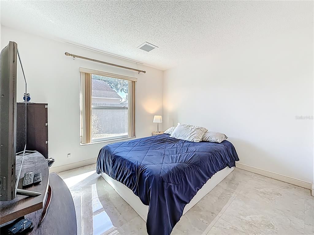 1909 Castle Bay Court Oldsmar, FL 34677 - Photo 29 of 48 a bedroom with a bed and flat screen tv