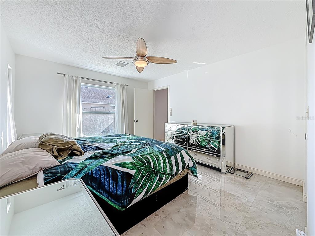 1909 Castle Bay Court Oldsmar, FL 34677 - Photo 4 of 48 a bedroom with a bed and a chandelier