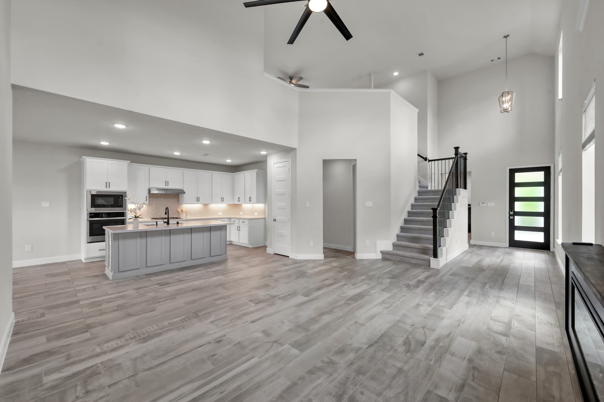 550 Chestnut Reef Court Conroe, TX 77304 - Photo 10 of 46 Expansive open layout with soaring ceilings, modern staircase, and seamless flow to the kitchen.