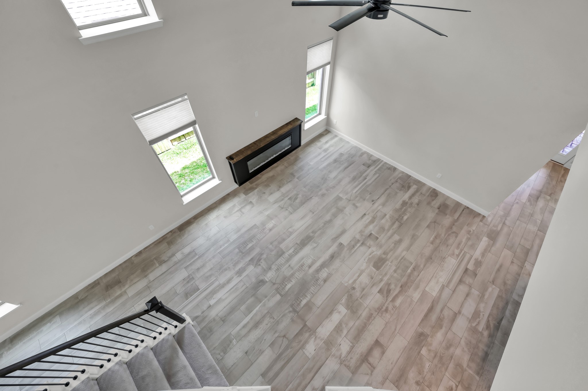 550 Chestnut Reef Court Conroe, TX 77304 - Photo 11 of 46 Overlook from above highlighting soaring ceilings, open layout, and modern fireplace focal point.
