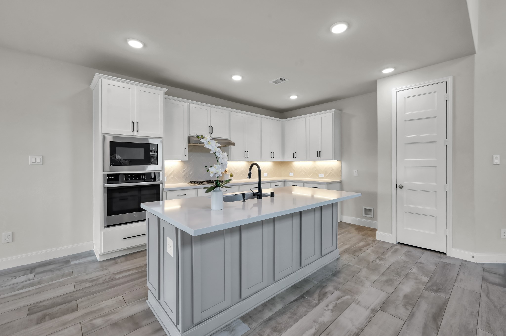 550 Chestnut Reef Court Conroe, TX 77304 - Photo 12 of 46 Chef’s kitchen with large island, quartz countertops, stainless steel appliances, and abundant cabinetry.