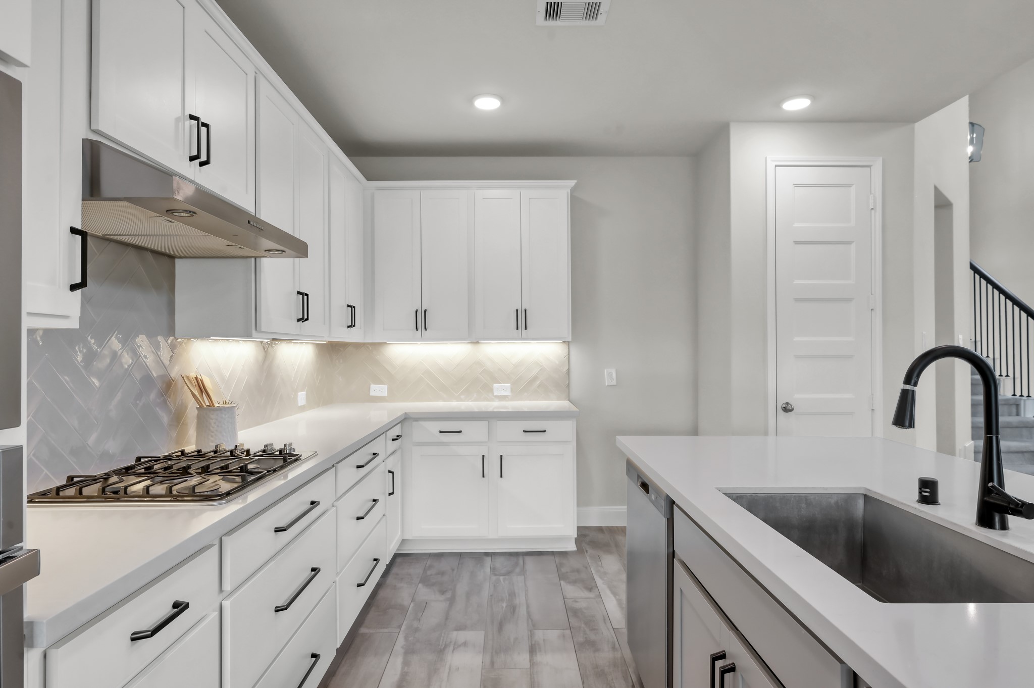 550 Chestnut Reef Court Conroe, TX 77304 - Photo 14 of 46 Bright kitchen with gas cooktop, sleek cabinetry, and stylish tile backsplash.