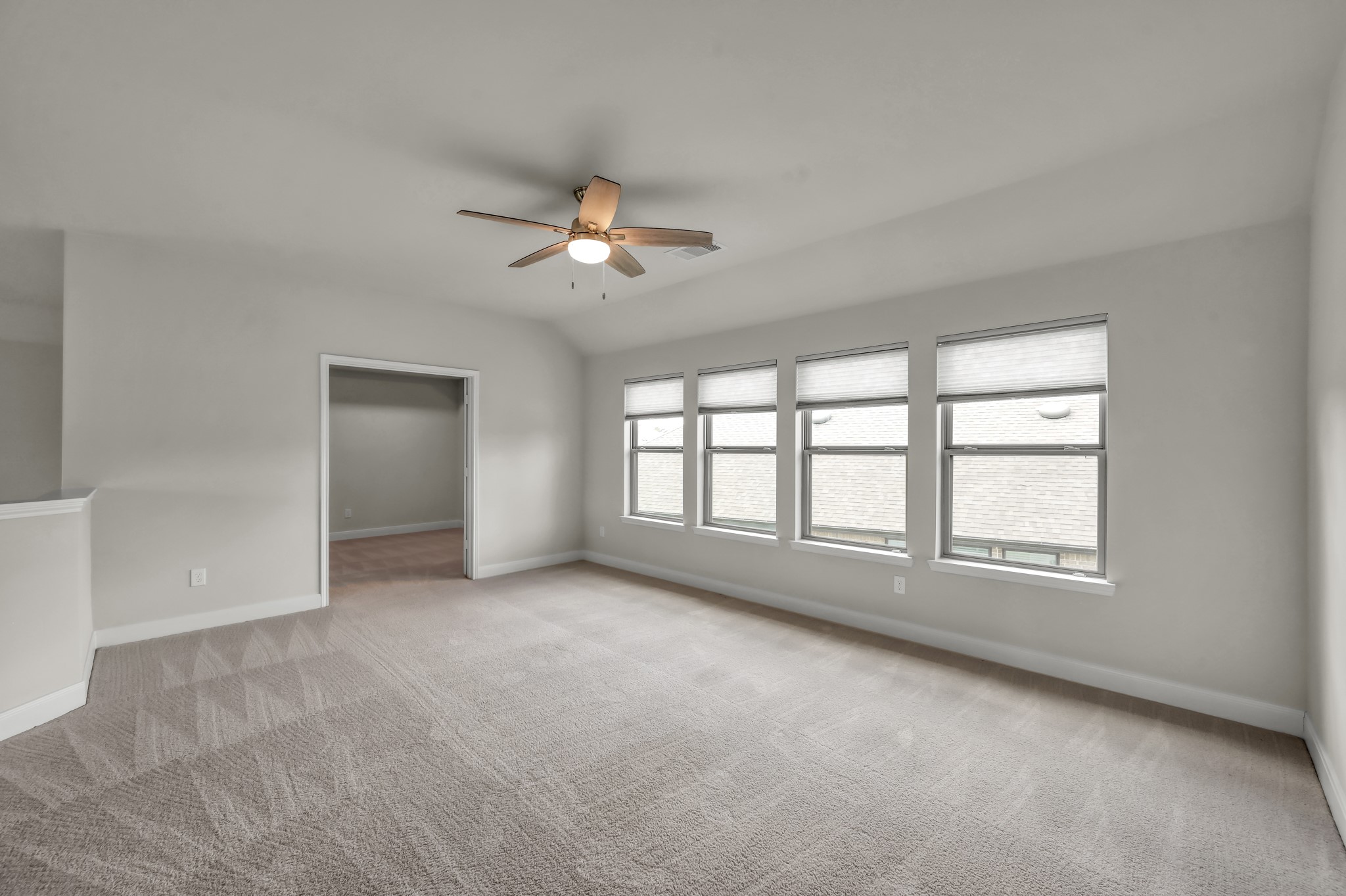 550 Chestnut Reef Court Conroe, TX 77304 - Photo 26 of 46 Spacious, bright game room with soft carpeting, multiple windows, and a clean, versatile layout.