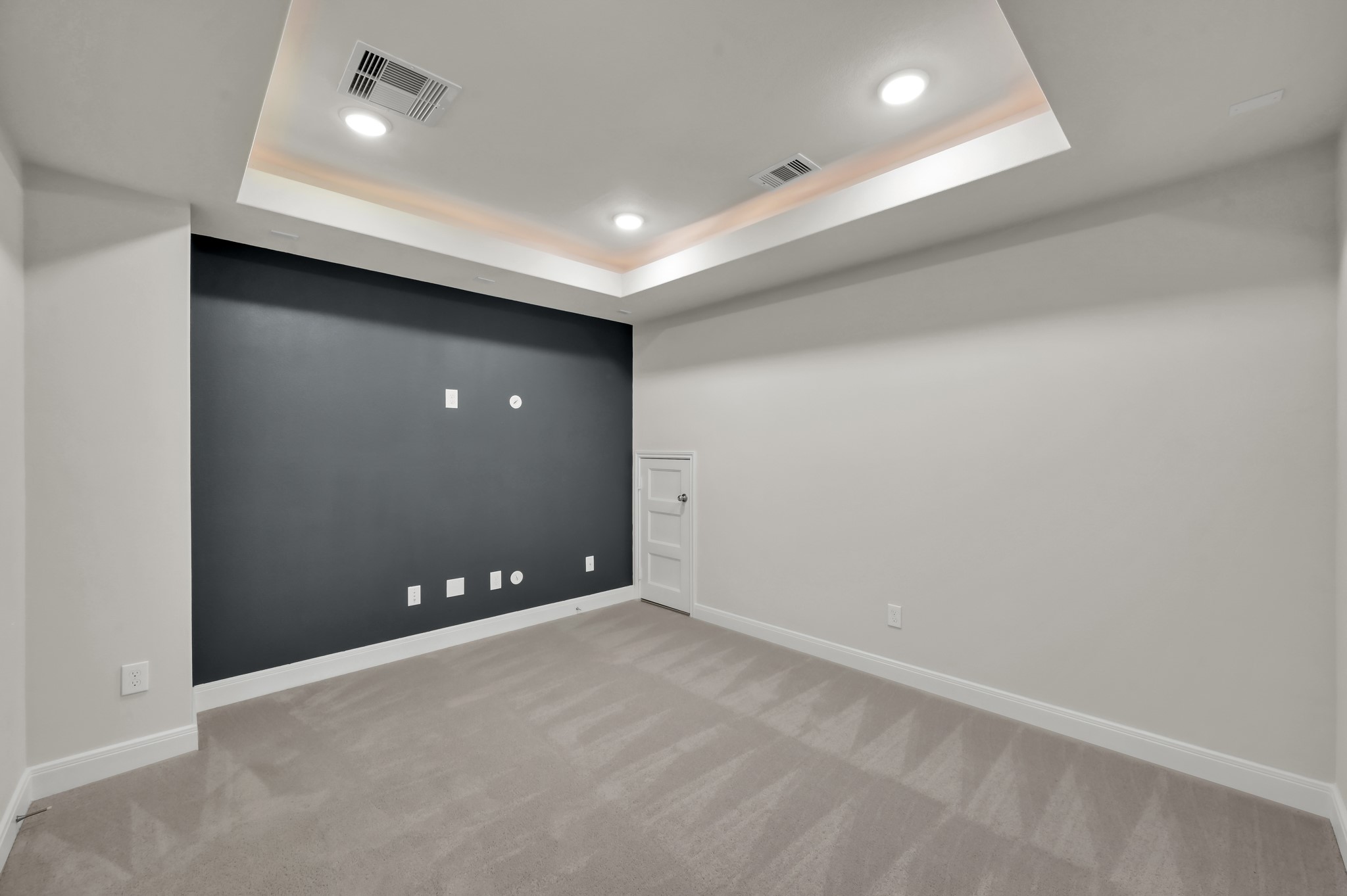 550 Chestnut Reef Court Conroe, TX 77304 - Photo 29 of 46 Cozy media room with tray ceiling, recessed lighting, and a bold accent wall ready for entertainment setup.