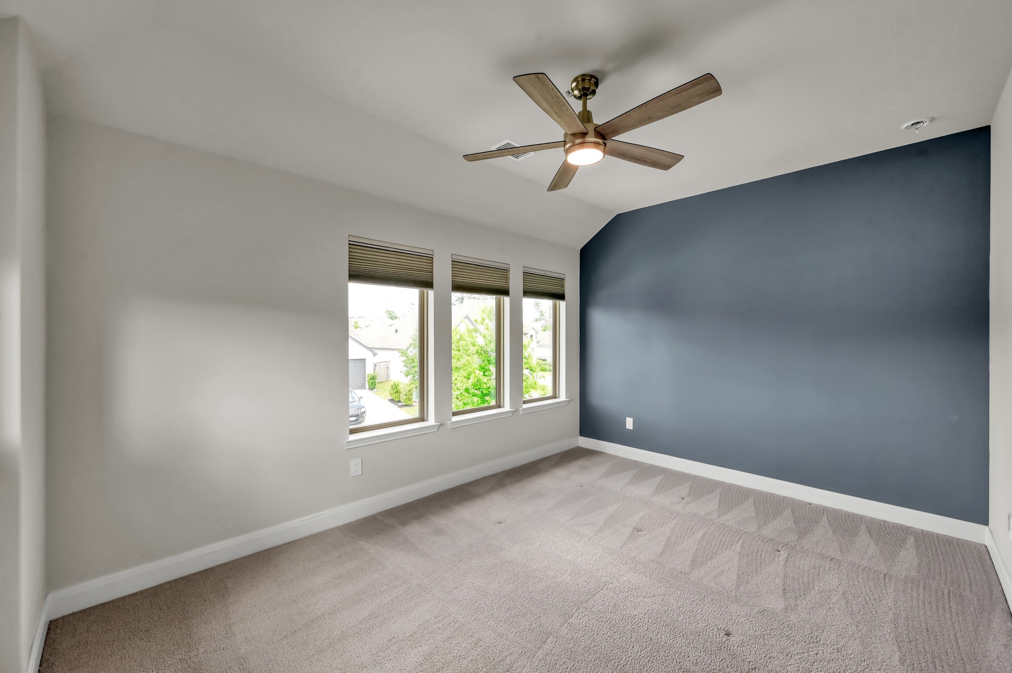 550 Chestnut Reef Court Conroe, TX 77304 - Photo 31 of 46 Bright secondary bedroom with clean carpeting, modern ceiling fan, and a stylish accent wall.