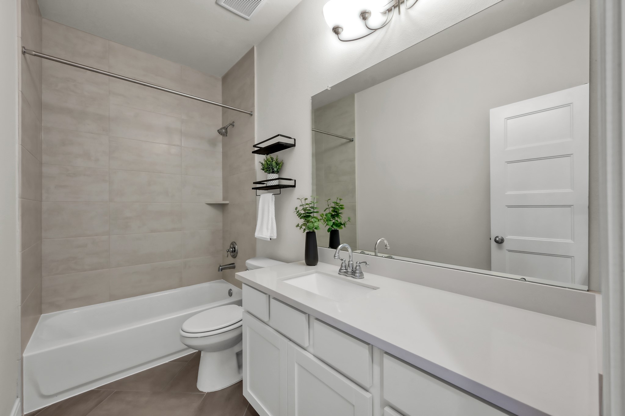 550 Chestnut Reef Court Conroe, TX 77304 - Photo 33 of 46 Clean, modern bathroom featuring a sleek vanity, large mirror, and tiled shower/tub combo for a fresh, move-in-ready feel.
