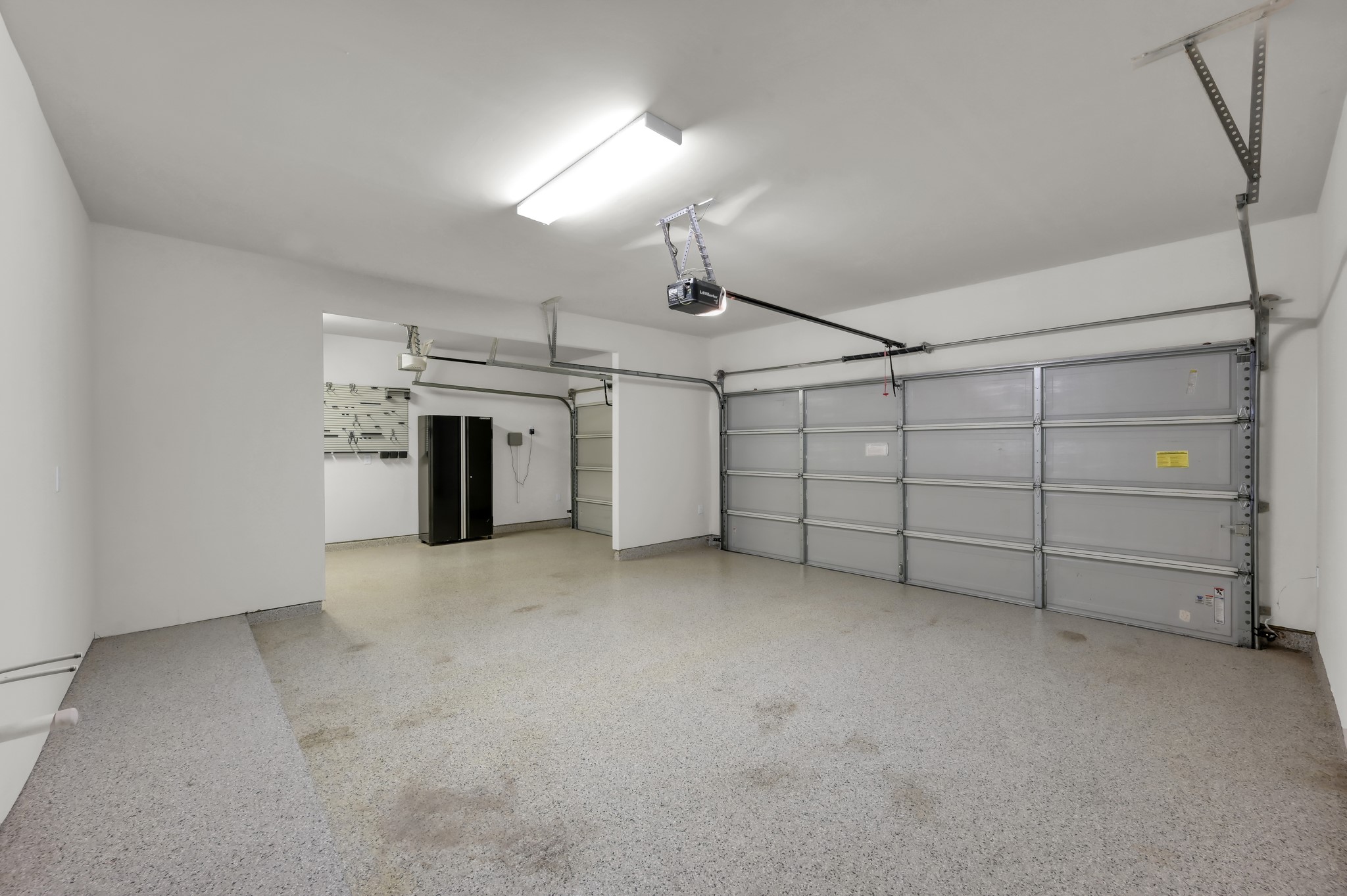 550 Chestnut Reef Court Conroe, TX 77304 - Photo 35 of 46 Oversized 3-car garage featuring durable epoxy flooring — perfect for storage or hobbies.