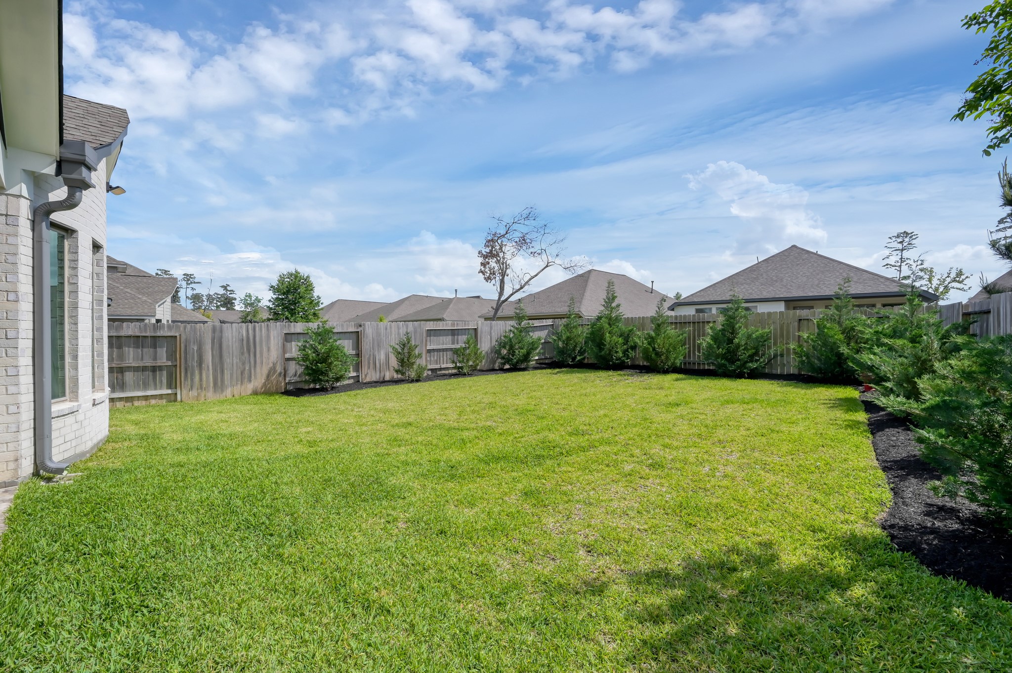 550 Chestnut Reef Court Conroe, TX 77304 - Photo 39 of 46 Spacious, fully fenced backyard with lush green lawn, fresh landscaping, and plenty of room for entertaining or outdoor additions.
