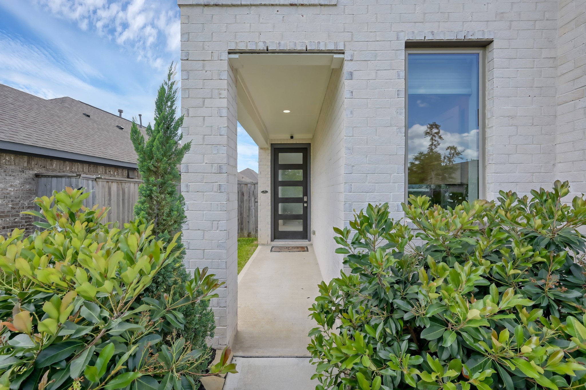 550 Chestnut Reef Court Conroe, TX 77304 - Photo 5 of 46 Inviting covered entry with modern front door and lush landscaping for added privacy.