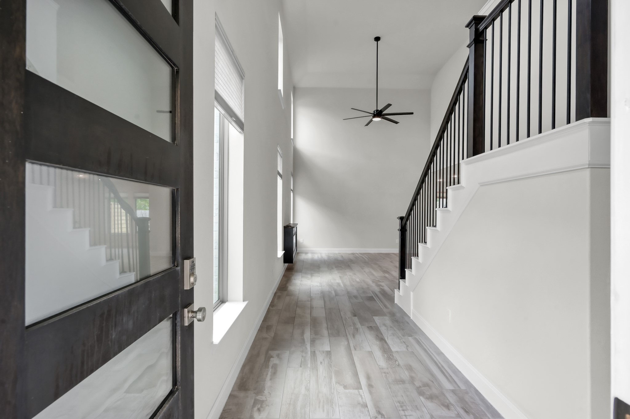550 Chestnut Reef Court Conroe, TX 77304 - Photo 7 of 46 Grand entry with soaring ceilings, wood-look tile flooring, and a striking staircase.