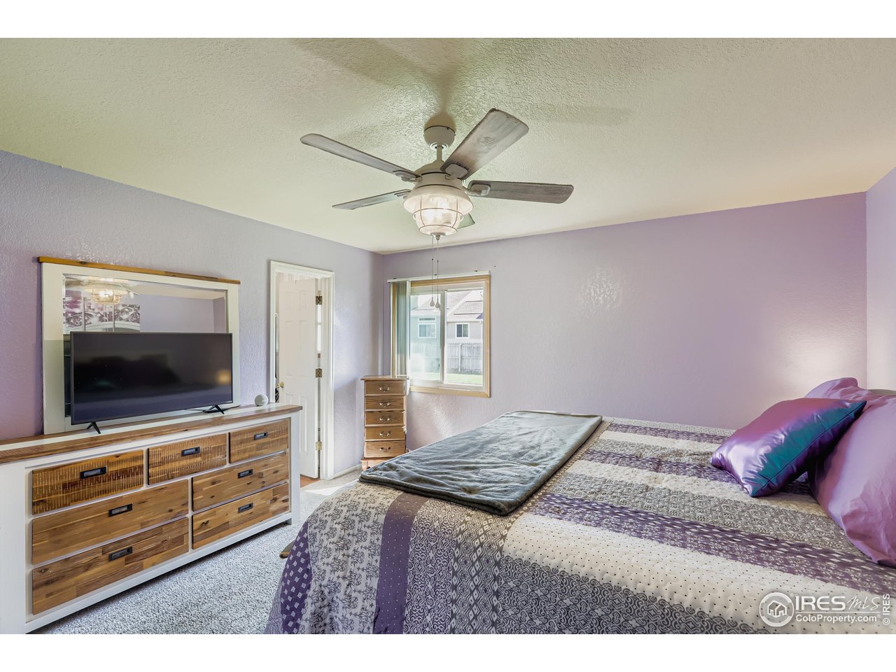 121 Chestnut Street Windsor, CO 80550 - Photo 15 of 42 a bedroom with a bed and a flat screen tv