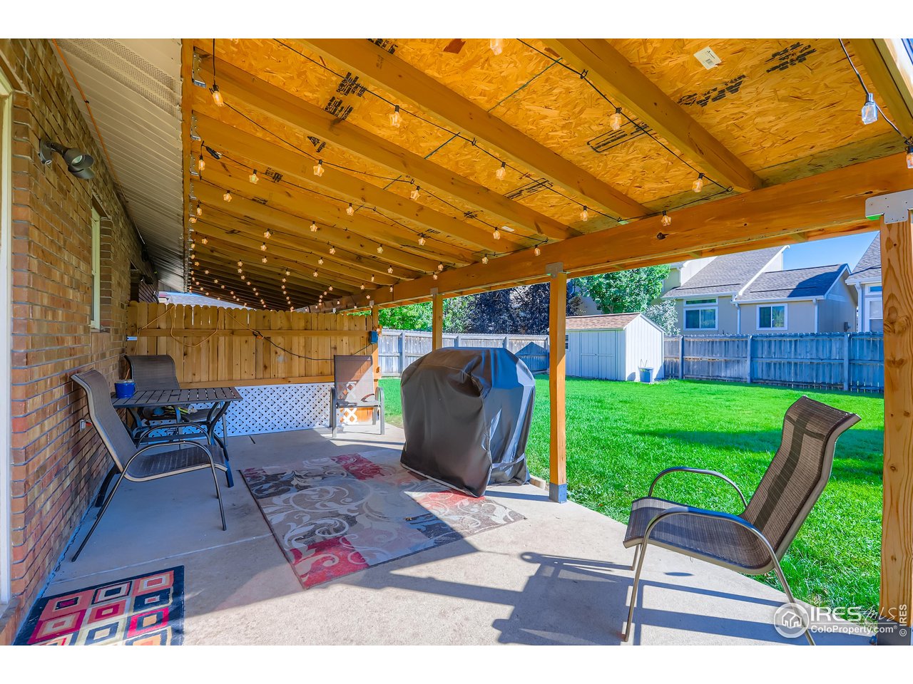 121 Chestnut Street Windsor, CO 80550 - Photo 22 of 42 a view of a patio with table and chairs with wooden floor and fence