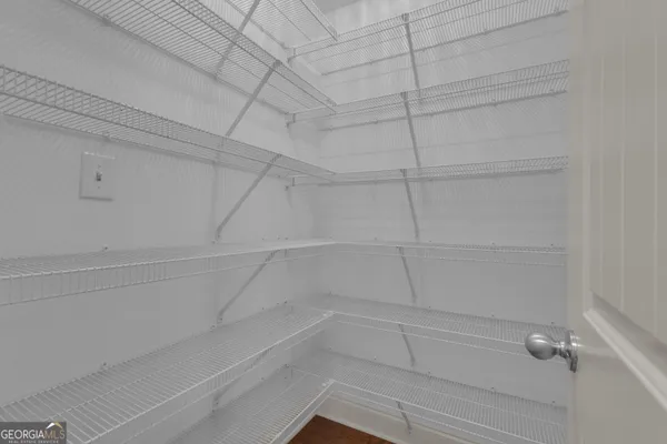 a view of an empty room with window and closet area