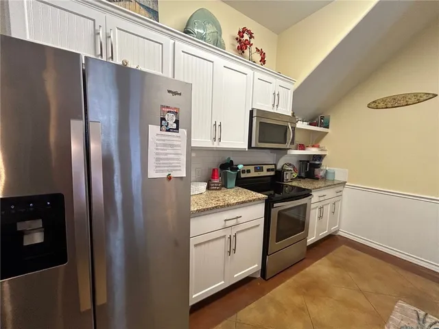 a kitchen with stainless steel appliances a refrigerator stove and microwave
