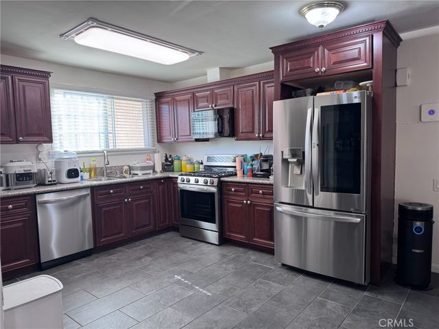 a kitchen with stainless steel appliances granite countertop a refrigerator stove and sink