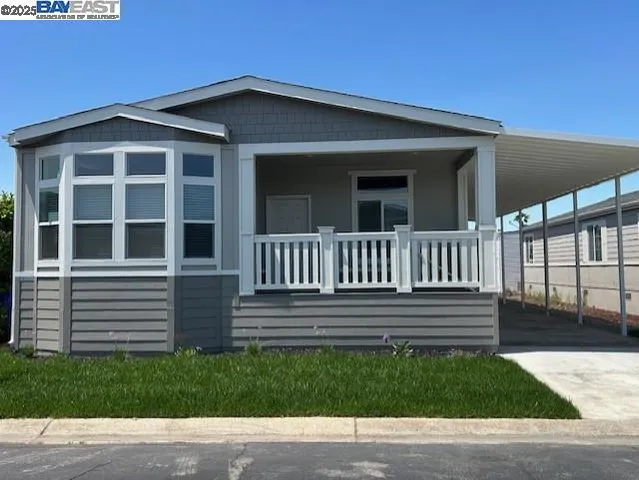 a view of a house with a small yard and wooden fence