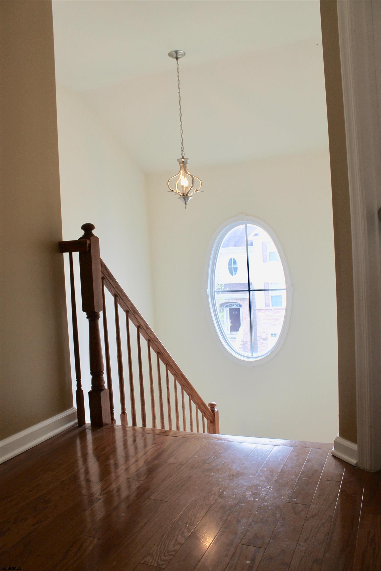 130 Dunlin Lane, Unit 16 Pleasantville, NJ 08232 - Photo 32 of 47 a view of a hallway with wooden floor and a chandelier