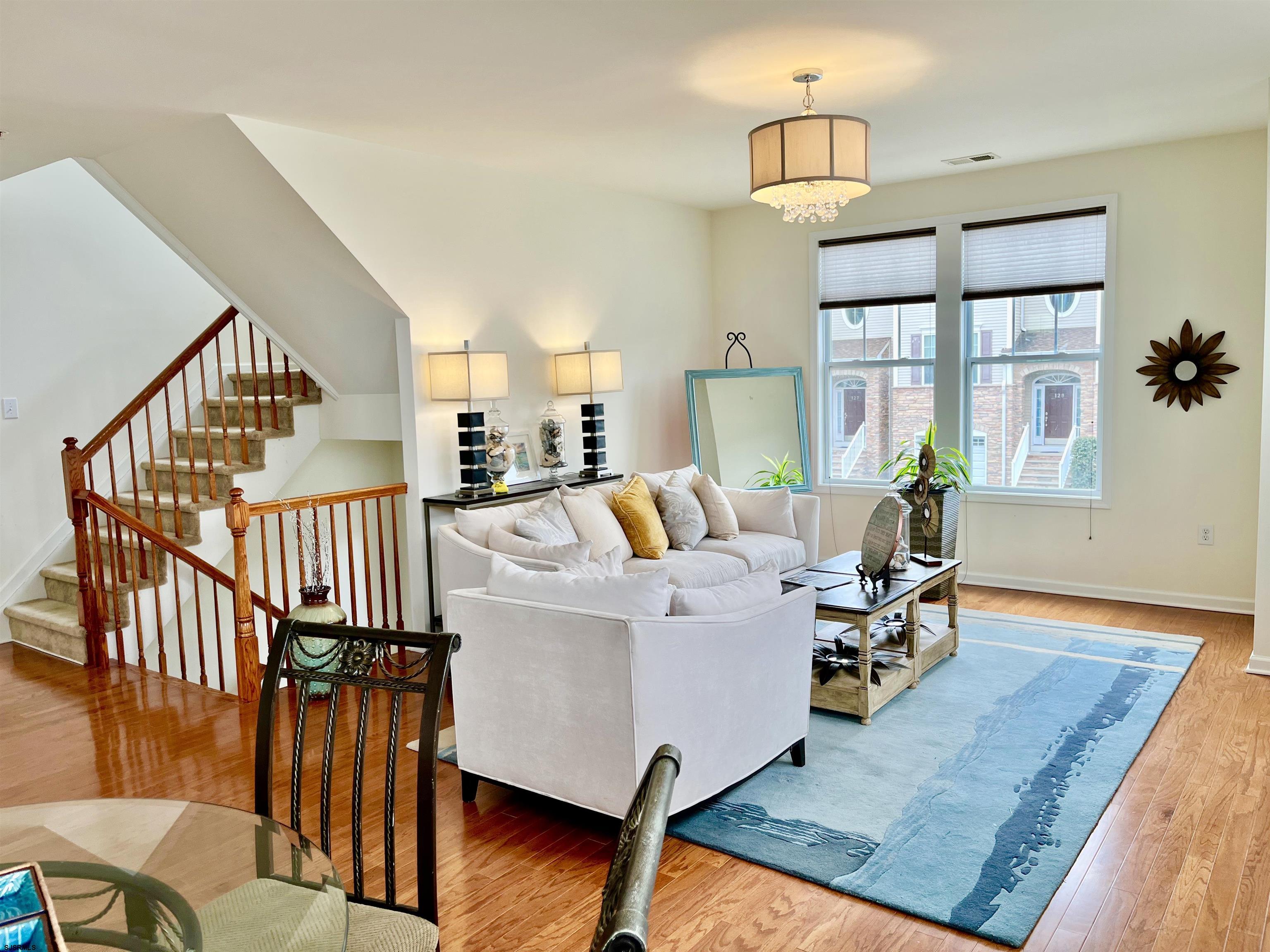130 Dunlin Lane, Unit 16 Pleasantville, NJ 08232 - Photo 4 of 47 a living room with furniture floor to ceiling window and wooden floor