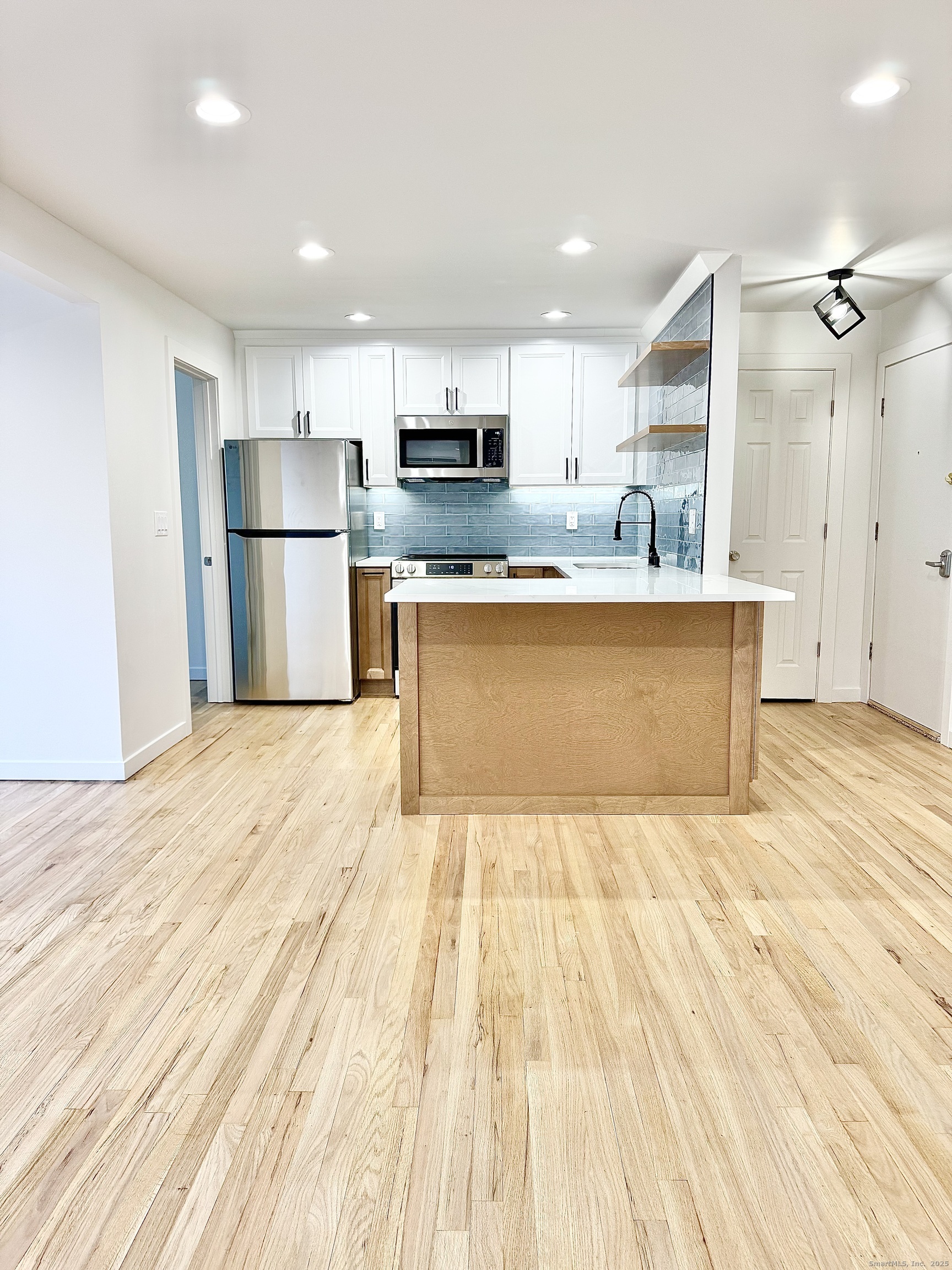 1742 Boston Post Road, Unit 3B Westbrook, CT 06498 - Photo 3 of 16 a large kitchen with stainless steel appliances a refrigerator and a stove top oven