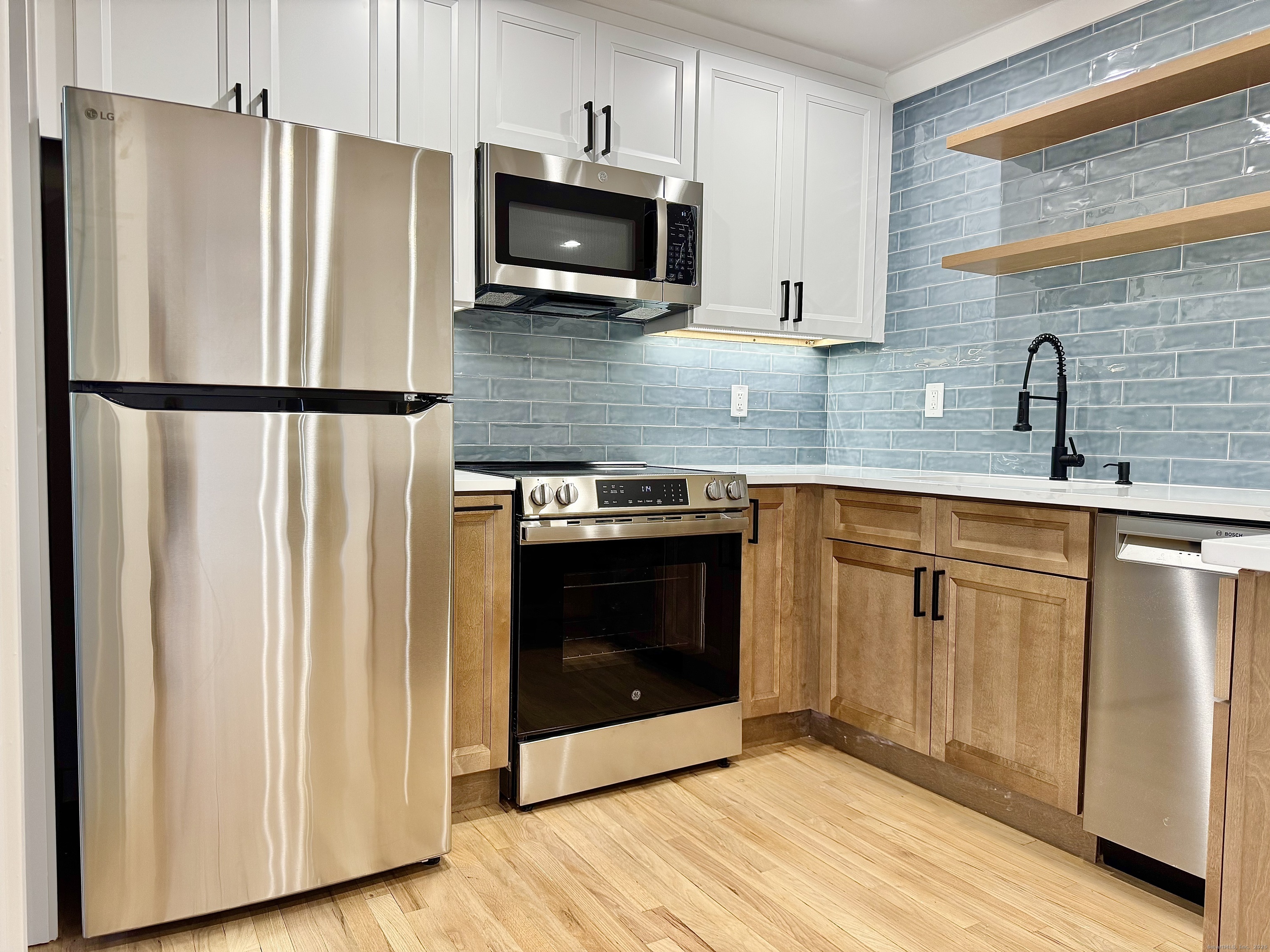 1742 Boston Post Road, Unit 3B Westbrook, CT 06498 - Photo 4 of 16 a kitchen with stainless steel appliances granite countertop a refrigerator a stove a sink and a microwave