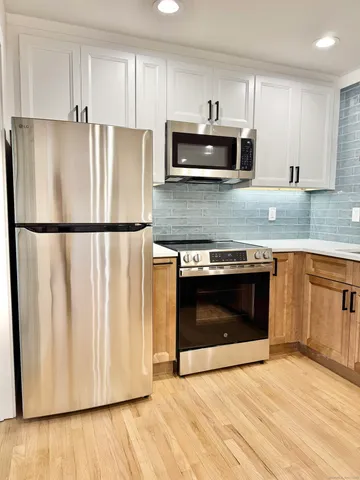 a kitchen with granite countertop white cabinets and stainless steel appliances