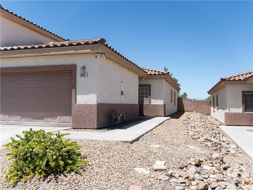 1466 Orange Jubilee Road Henderson, NV 89014 - Photo 1 of 15 A well-maintained facade features an attached garage and desert-friendly landscaping, presenting an inviting curb appeal.