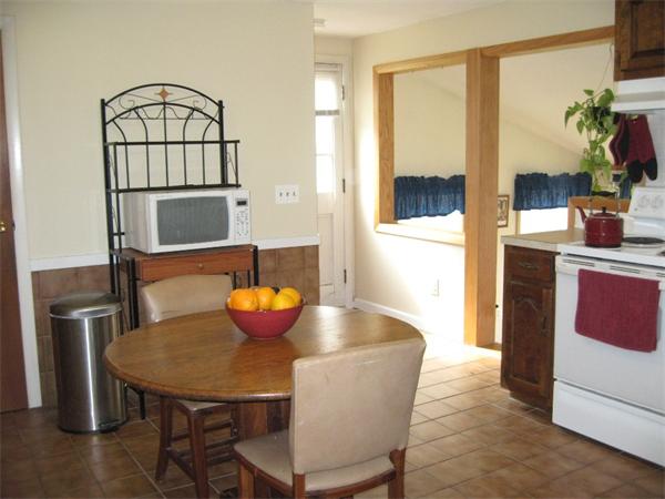 74 Aspen Road Springfield, MA 01128 - Photo 9 of 26 a kitchen with stainless steel appliances granite countertop a table chairs in it and wooden floors
