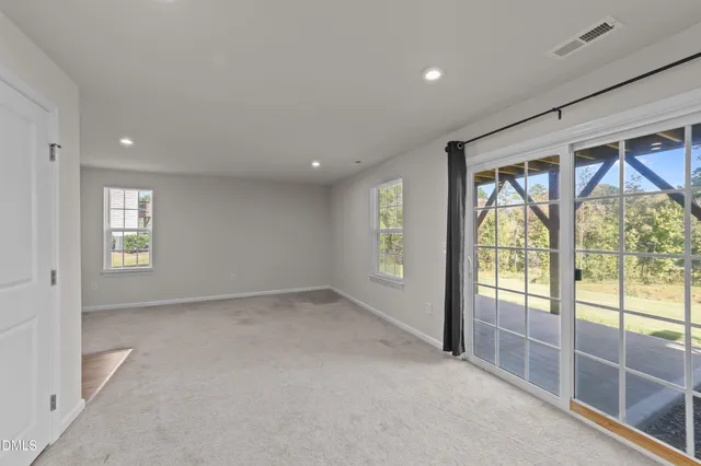 an empty room with windows and view of an outdoor space